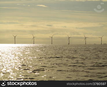 wind turbines power generator farm for renewable energy production along coast baltic sea near Denmark at sunset /sunrise. Alternative green energy. ecology.