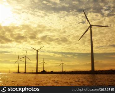 wind turbines power generator farm for renewable energy production along coast baltic sea near Denmark at sunset /sunrise. Alternative green energy. ecology.