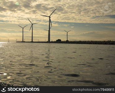 wind turbines power generator farm for renewable energy production along coast baltic sea near Denmark at sunset /sunrise. Alternative green energy. ecology.