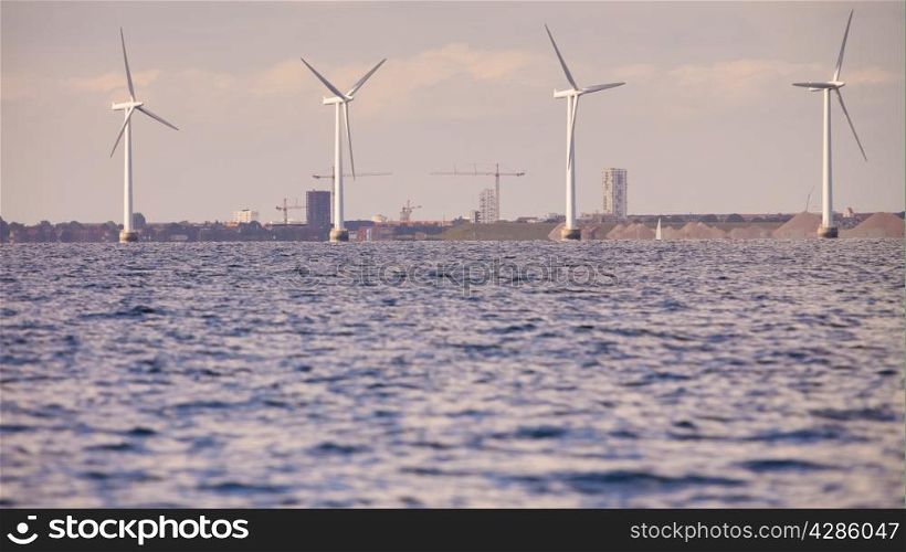 wind turbines power generator farm for renewable energy production along coast baltic sea near Denmark. Alternative green energy ecology.