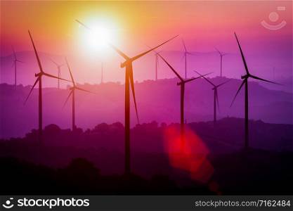 Wind turbines silhouette on mountains at sunset. Concept of renewable clean energy and sustainability development business from wind energy.