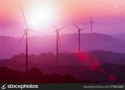 Wind turbines silhouette on mountains at sunset. Concept of renewable clean energy and sustainability development business from wind energy.