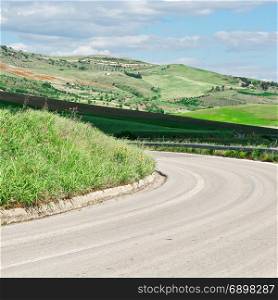 Winding Asphalt Road between Stubble Fields of Sicily