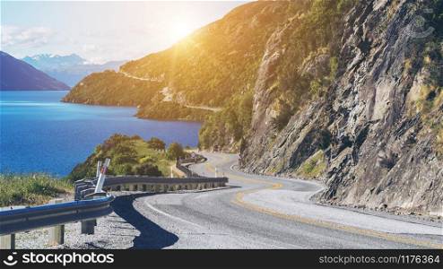 Winding road along mountain cliff and lake landscape in Queenstown, New Zealand South Island. Travel and road trip in summer.. Winding Road along Mountain Cliff and Lake