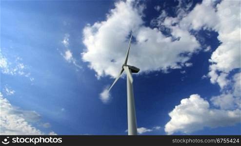 Windkraftanlage vor blauem Himmel mit wei?en Wolken, Totale, feste Einstellung, Nordrhein Westfalen, Deutschland.