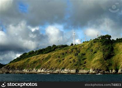 windmill for renewable energy on the island with beautiful sky background