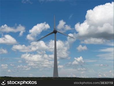 windmill in holland with blue sky and white clouds in the field