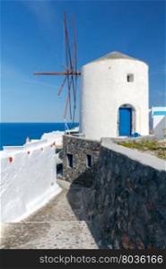 Windmill in Oia village.. Traditional white windmill in the village Oia. Santorini. Greece.