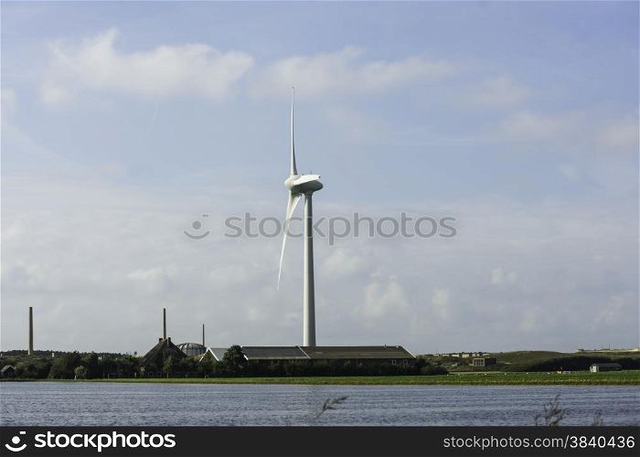 windmill in the fields with flowers in the foreground