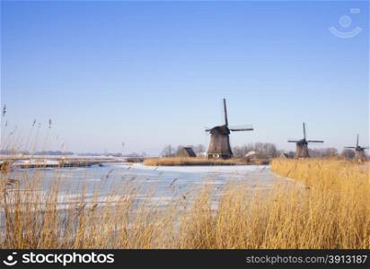 Windmill in winter time with snow and blue sky