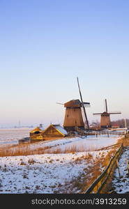 Windmill in winter time with snow and blue sky