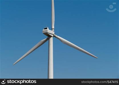 Windmill power generator against blue sky. Close up. Windmill power generator against sky. Close up