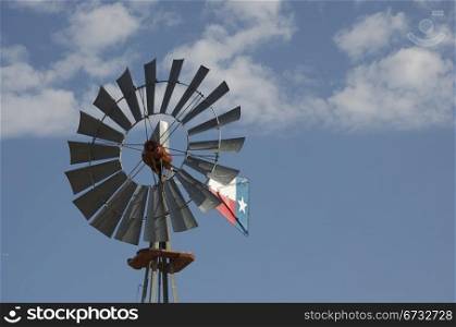 Windmill with Texas Flag against a blue sky