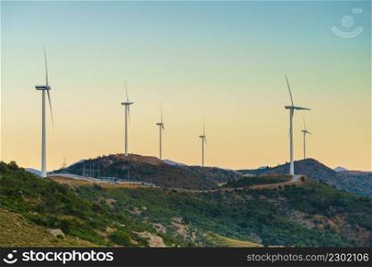 Windmills on Greek hills. Wind farm, source of renewable green energy in Europe. Ecologogy concept.. Windmills on Greek hills