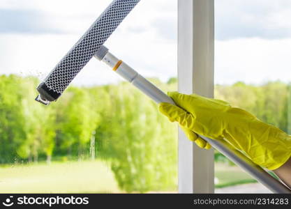 Window cleaning. A young woman sprays a cleaner on glass. Housework concept.. Window cleaning. A woman sprays a cleaner on glass. Housework concept.