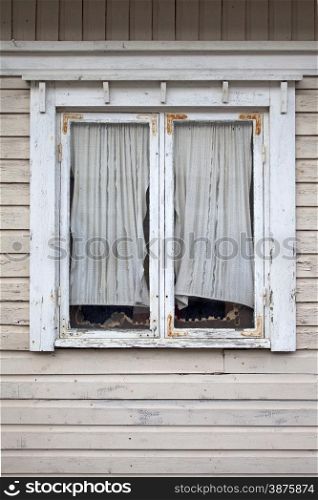 Window of a old wooden cottage with curtain