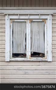 Window of a old wooden cottage with curtain