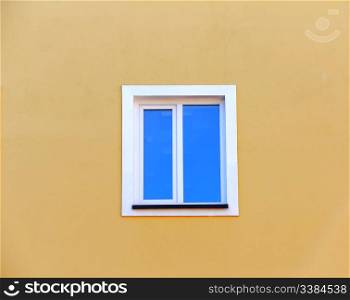 window on a yellow background wall of the house