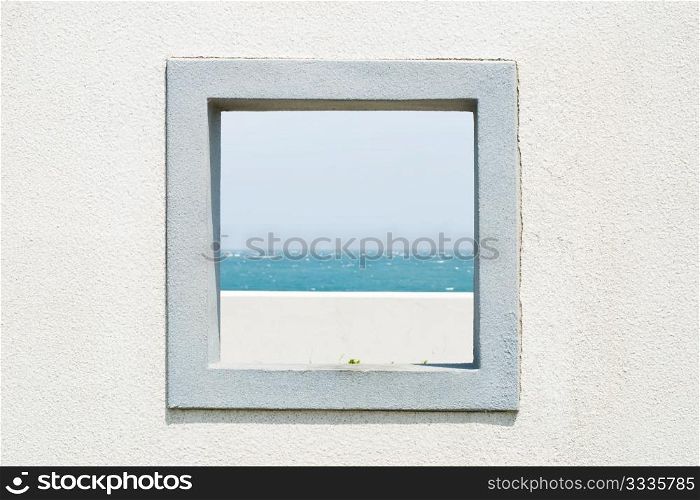 Window on the wall with seascape and sky in the garden.