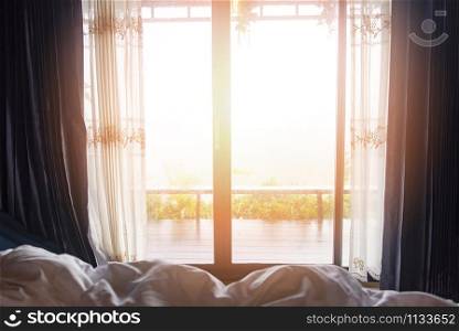 window view nature green mountain in the bed at bedroom morning and sunlight / window glass with drapery