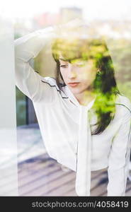 Window view of businesswoman daydreaming in office