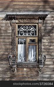 Window with carved architraves in old wooden house