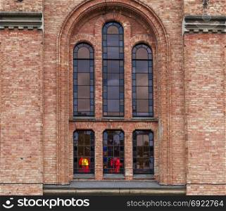 window with stained-glass windows in a red brick chapel