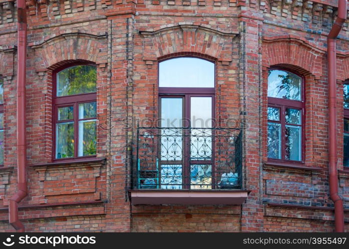 windows and balcony of a brick building in vintage style close-up