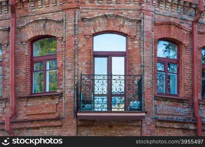 windows and balcony of a brick building in vintage style close-up