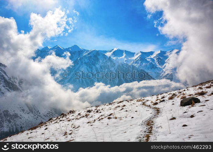 Windows of clouds in mountains. Beautiful misty rock landscape with snow and clouds. Great view of the foggy Ala-Archa National Park in Kyrgyzstan.