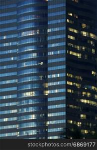 windows of office buildings illuminated at night for background