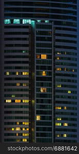 windows of office buildings illuminated at night for background