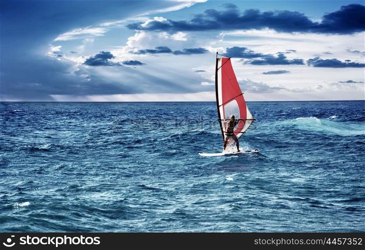 Windsurfer in the sea, man on windsurf conquering the waves, enjoying extreme sport, active lifestyle, happy summer vacation&#xA;