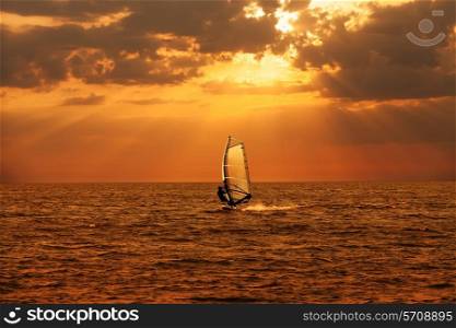 Windsurfer sailing in the sea at sunset&#xA;