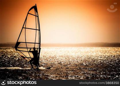 windsurfer silhouette against a sunset background