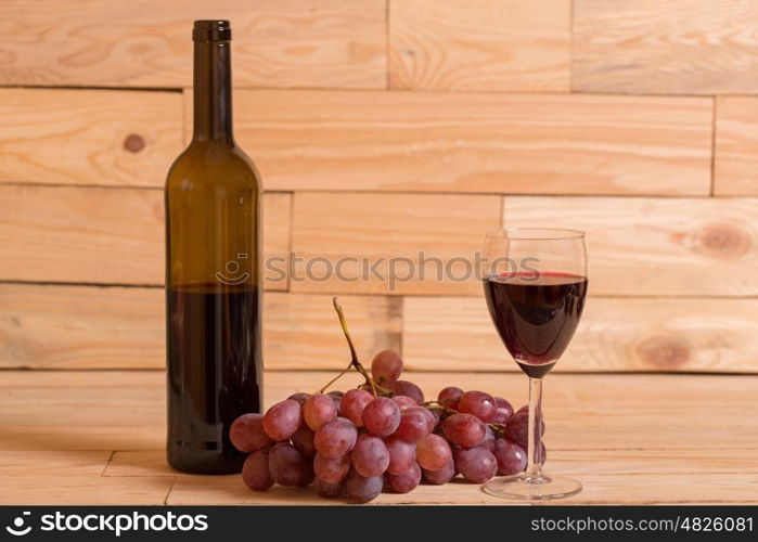 wine and grapes on a wooden background