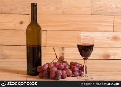 wine and grapes on a wooden background