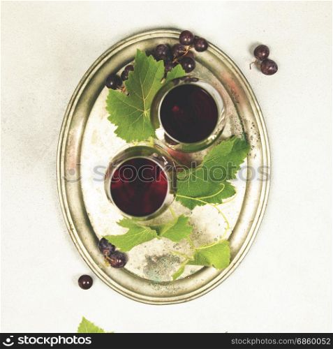 Wine and grapes over grey marble background, top view, copy space