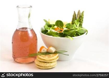 wine and salad. a bottle of rose wine with a cup of salad and surimi