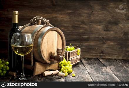 Wine background. A barrel of white wine with branches of green grapes. On a wooden background.. Wine background. A barrel of white wine with branches of green grapes.