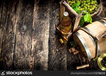 Wine background. A barrel of white wine with branches of green grapes. On a wooden background.. Wine background. A barrel of white wine with branches of green grapes.