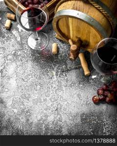 Wine background. A barrel with red wine and fresh grapes. On a rustic background.. Wine background. A barrel with red wine and fresh grapes.