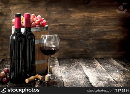 Wine background. A barrel with red wine and freshly grapes. On a wooden background.. Wine background. A barrel with red wine and freshly grapes.