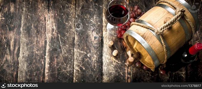 Wine background. A barrel with red wine and freshly grapes. On a wooden background.. Wine background. A barrel with red wine and freshly grapes.