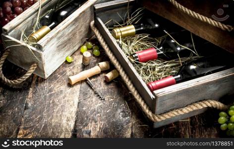 Wine background. Bottles of red and white wine in old boxes. On a wooden background.. Wine background. Bottles of red and white wine in old boxes.