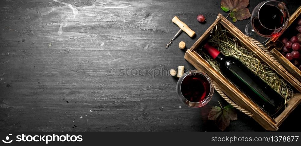 Wine background. Red wine in an old box with a corkscrew. On the black chalkboard.. Wine background. Red wine in an old box with a corkscrew.