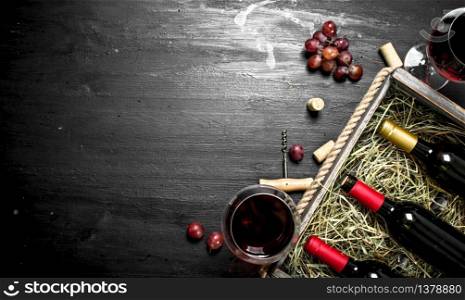 Wine background. Red wine in an old box with a corkscrew. On the black chalkboard.. Wine background. Red wine in an old box with a corkscrew.