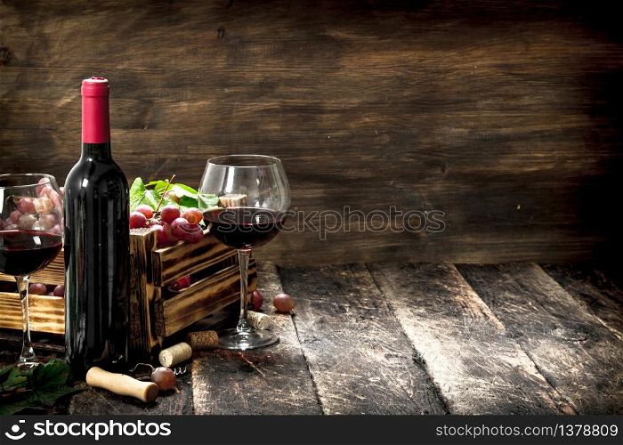 Wine background. Red wine with a box of grapes. On a wooden background.. Wine background. Red wine with a box of grapes.