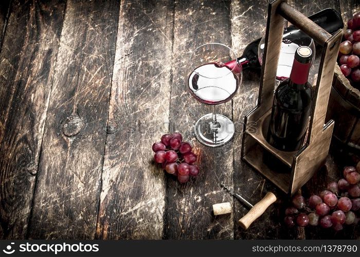 Wine background. Red wine with glasses with grapes. On a wooden background.. Wine background. Red wine with glasses with grapes.