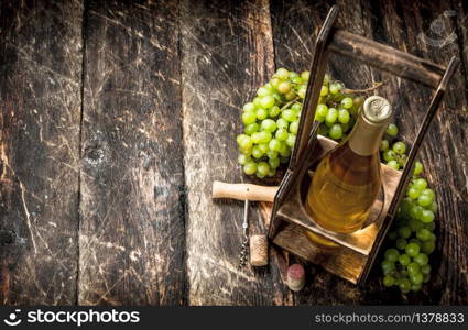 Wine background. White wine on a stand with branches of fresh grapes. On a wooden background.. Wine background. White wine on a stand with branches of fresh grapes.